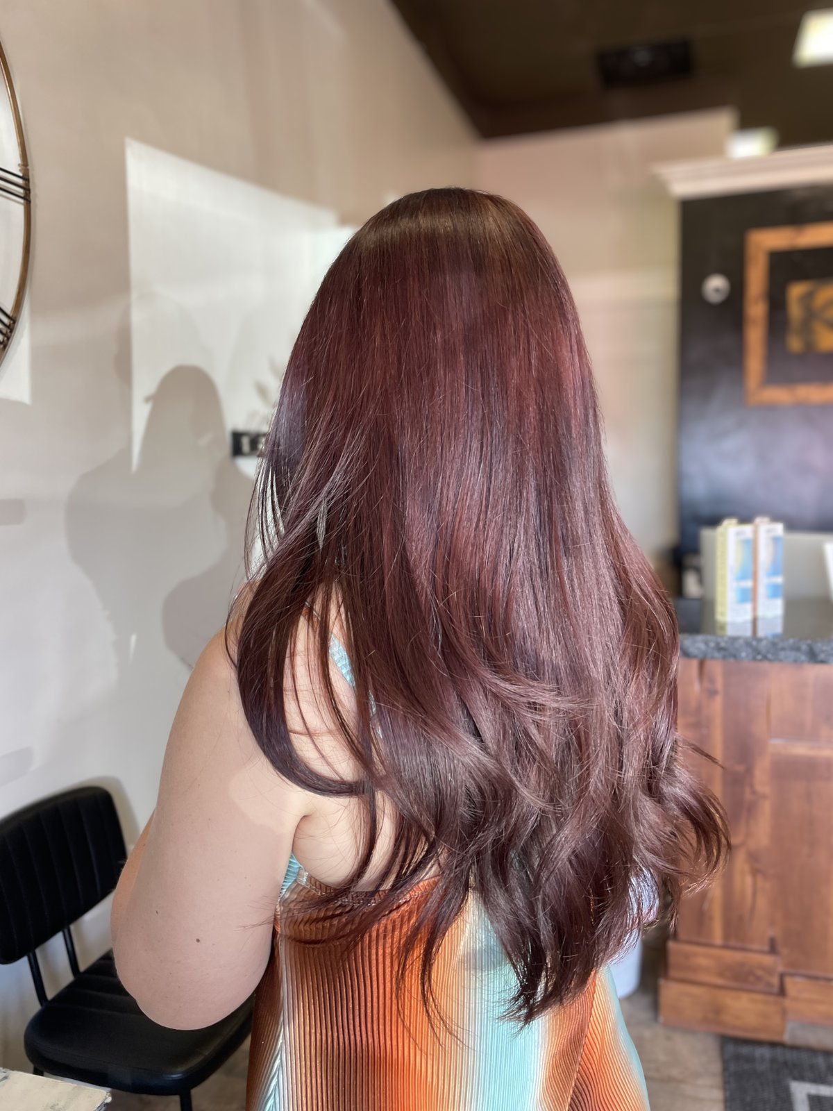 Deep cherry red hair color on long, sleek hair