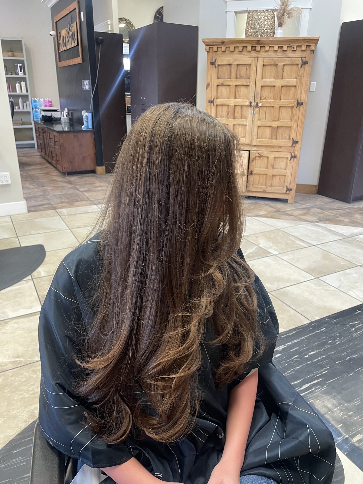 Long brunette with caramel lowlights and a curled blowout