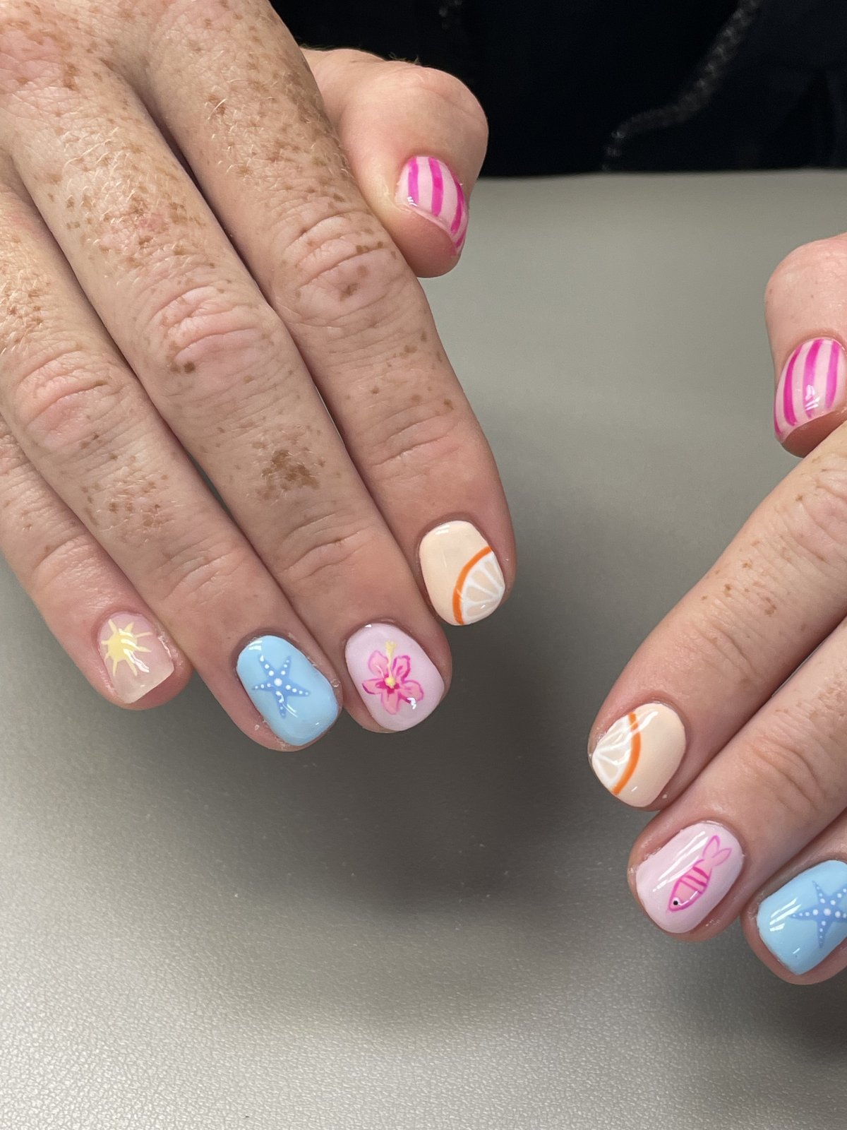 Summer beach nail art with starfish, hibiscus, and citrus details
