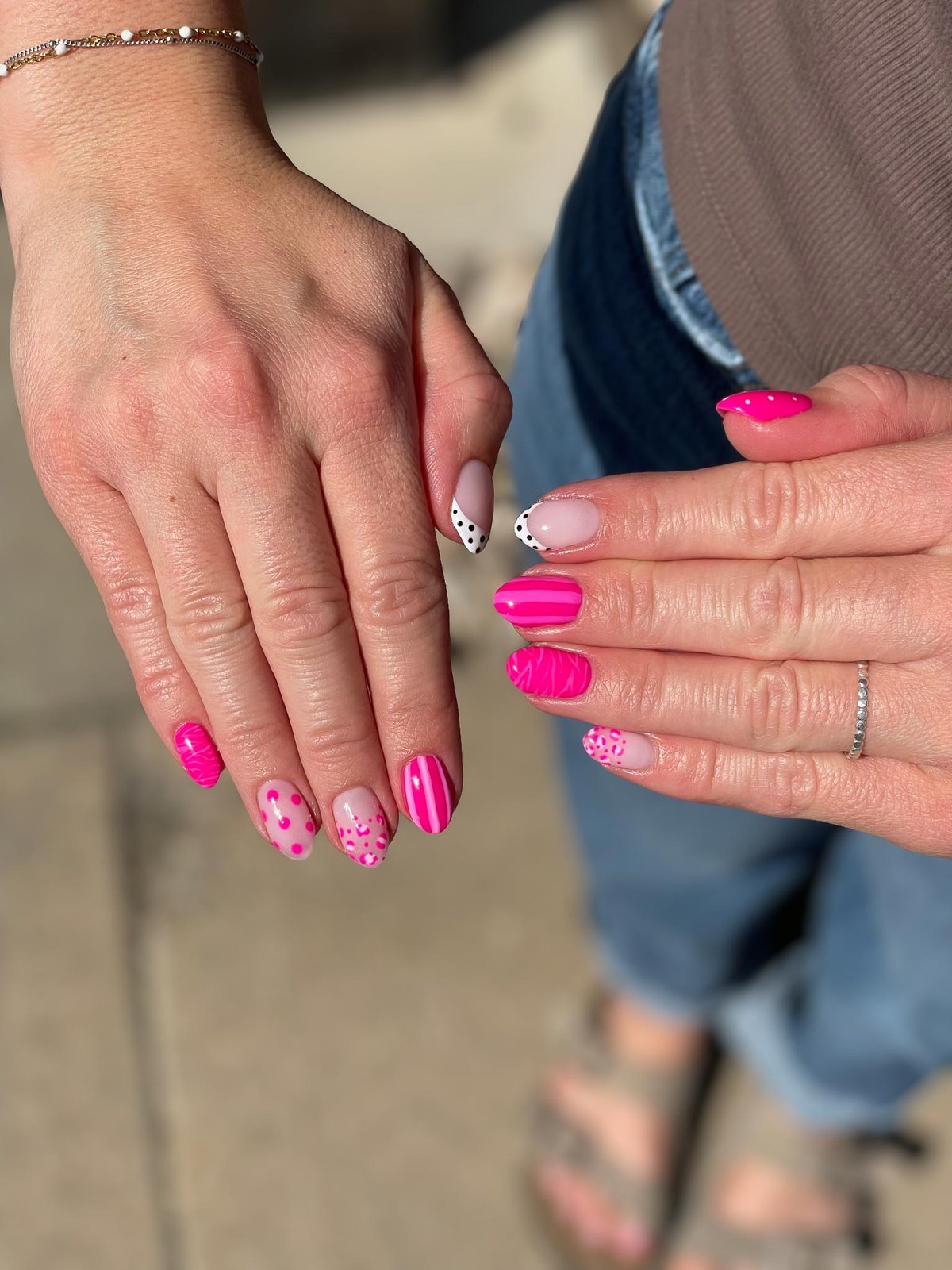 Hot pink nail art with stripes, hearts, and animal print