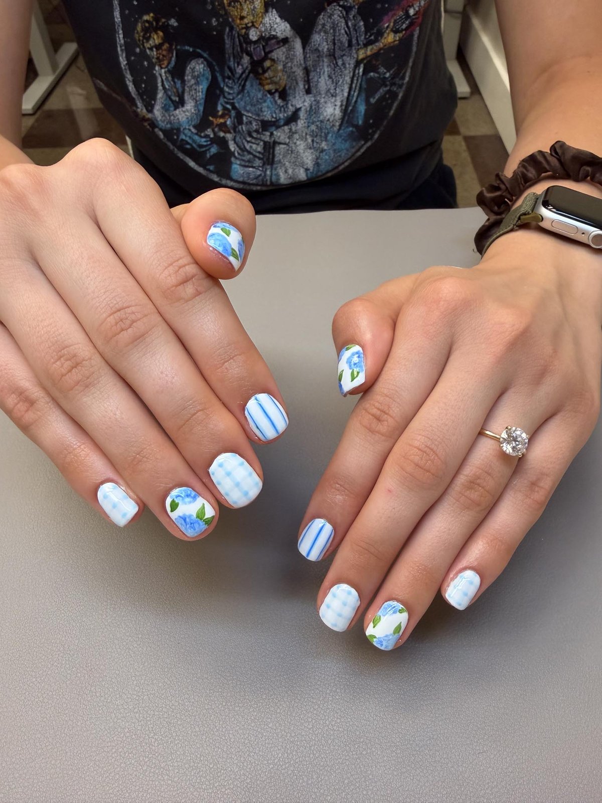Blue and white floral nail art with gingham and stripe accents